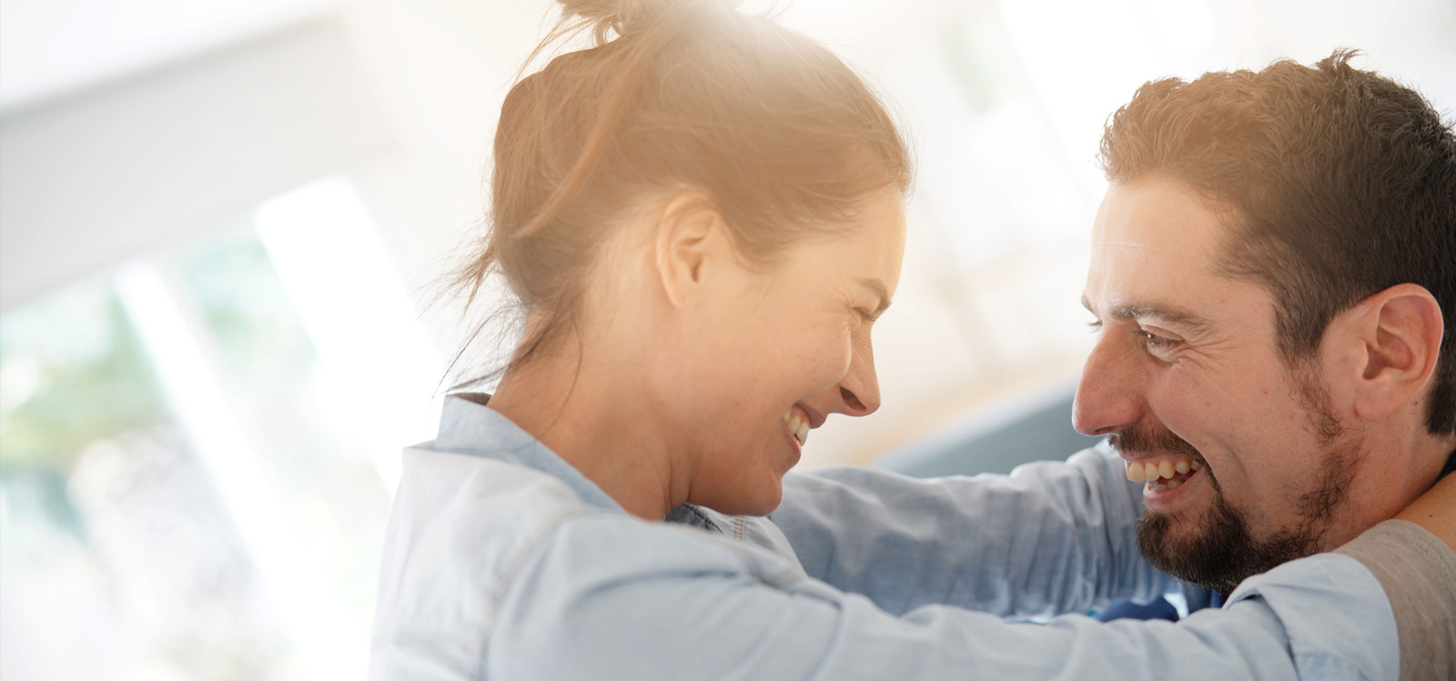 Um casal a abraçar-se e a sorrir um para o outro Um casal a abraçar-se e a sorrir um para o outro
